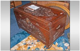 A Chinese Export Carved Camphor Wood Chest, depicting monks in a classical garden setting to the top