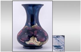 William Moorcroft Bulbous Shaped Vase, pansy design on blue ground. Moorcroft marks to underside.