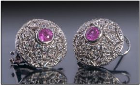 18ct White Gold Pair Of Diamond And Ruby Earrings, Set With A Central Round Ruby Surrounded By Small