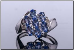 9ct White Gold Dress Ring, Set with Seven Oval Tanzanite's Between Two Diamond Spacers, Fully