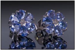 Pair Of Tanzanite Floral Cluster Earrings, each earring comprising 6 pear cut tanzanites surrounding