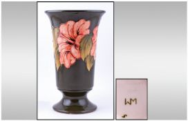 Walter Moorcroft Tall Vase. Coral Hibiscus design on green ground. Stands 11 inches high.
