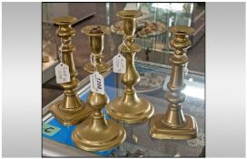Two Pairs Of Brass Candlesticks. All with pushers. Raised on circular and rectangular bases, of knot