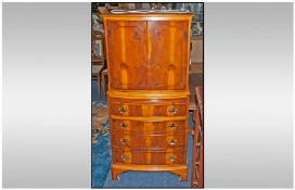 A Reproduction Yew Wood Tallboy Cocktail Cabinet, bow fronted, cupboards above with a drinks slide