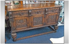 A Mock Jacobean Oak Sideboard, with three drawers and three cupboards below, fully carved with a