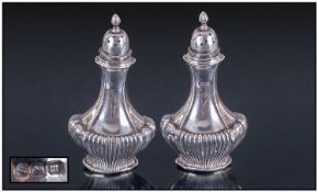 A Silver Pair Of Art Deco Pepperettes. With ribbed half bodies and tapered necks. Hallmark Sheffield