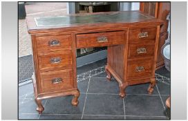 An Edwardian Walnut Knee Hole Leather Top Desk. With central drawer and a bank of three drawers