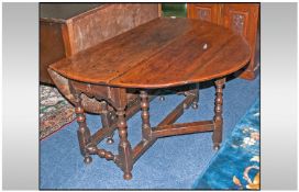 An Early 18th Century Oak Gateleg Table, on turned baluster legs and cross stretchers. With a single