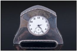 A Silver Cased And Shaped Small Table/Desk Clock, with piecrust borders and pocket watch size