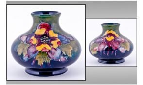 Moorcroft Small Squat Vase, Orchids design on green and blue ground. Circa 1940's. Height 3 inches.