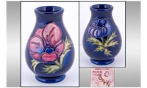 Moorcroft Small Vase. Clematis design on blue ground. Moorcroft marks to underside. Excellent