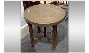 Middle Eastern Brass Topped Occasional Table, with folding cross stretcher base. Diameter 23.5