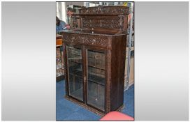 Double Door Glazed Bookcase in carved oak, in the Dutch style. Supported by a shelf top with