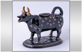 Black Staffordshire and Gilded Cow Creamer and Lid. On an Oval Base. Late 19th Century.