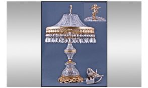 Cut Glass Table Lamp. With brass fittings and cherub finial. The shade with prism drops. Height 19