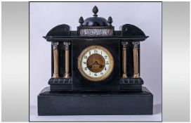 A Large Black Victorian Slate Mantle Clock in the classical Greek Style. With a domed finial top