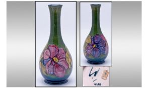 Moorcroft Bottle Shaped Vase 'Clematis' Design on green ground. Date 1980. 10.5" in height.