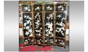 A Chinese Black Lacquer Gilt Decorated Four Fold Screen. The centre panels finely carved with mother