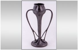 A Liberty & Co English Pewter tulip vase, designed by Archibald Knox, the bulbous neck above a