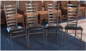 Set of Four Metal Framed Dining Chairs with black seats.