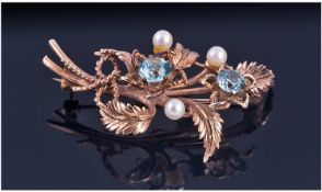 Ladies 9ct Gold Brooch. In the form of a flower set with pearls and aquamarine coloured stones.