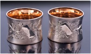 An Attractive Pair Of Silver and Silver Gilt Napkin Rings. Frosted exterior with vacant cartouche.