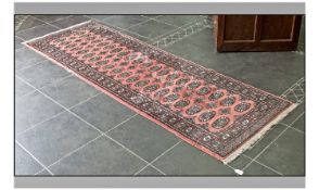 Persian Style Rug, predominantly salmon coloured background with geometric pattern. 100 by 32