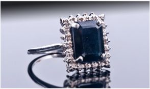 9ct White Gold Diamond And Sapphire Ring, Set With A Central Dark Sapphire Surrounded By Round Cut