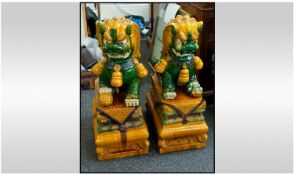 A Pair Of Chinese Foo Temple Dogs On Stand, glazed pottery Sancai ware. Highly decorated in green &