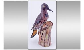 A Continental Porcelain Figure of a Woodpecker on a Tree Trunk. Brightly coloured in its natural