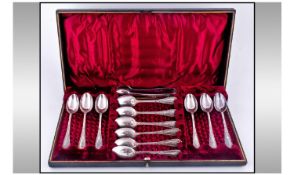Edwardian Cased Set Of 12 Silver Plated Teaspoons And Matching Sugar Tongs. Red velvet interior.