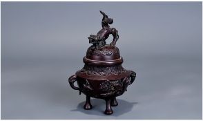 A Chinese Bronze Censor, on tripod base terminating with a Dog of Foo finial..7 inches in height