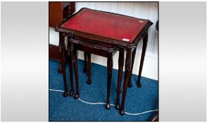 Nest of Three Mahogany Shaped Tables, leather tooled tops with glass inserts.