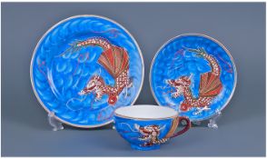 Oriental Cup Saucer And Side Plate Trio. Designed with maroon and green dragon pattern on blue
