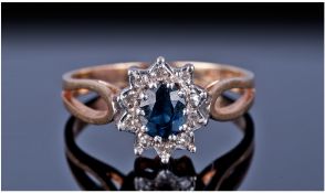 9ct Gold Diamond And Sapphire Cluster Ring. Central Sapphire Surrounded By 10 Round Cut Diamonds,