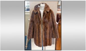 Short length Mink Coat. Slit pockets, fully lined. Half back belt. Label reads 'Continental Furs