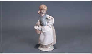 Lladro Figure, of a girl holding a basket in one hand and a lamb in the other. 10 inches in height.