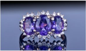 9ct Gold Diamond And Amethyst Cluster Ring. Set with three oval amethysts surrounded by round