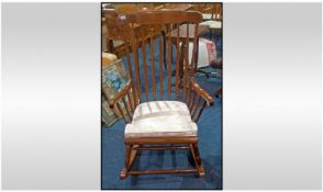 A Reproduction Mahogany Rocking Chair, in the American Colonial style. With a slated back and