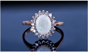 9ct Gold Set Opal And Diamond Ring. The central opal surrounded by 20 small diamonds. Fully