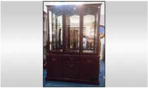 A Mahogany Glazed Top Cabinet On Base. The base consisting of two cabinets with a central draw and