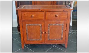 A Stained Beech Two Drawer Cupboard with inlaid coconut shelves. On small tapering feet.  36 inches