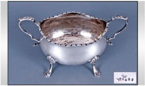 A Silver Two Handle Sugar Bowl, raised on four shell and splayed feet. Height 4 inches. Hallmark