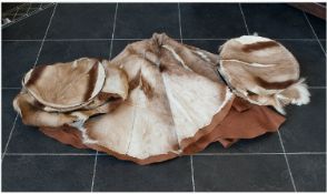 Three Pieces of Impala Skins comprising two pouffes and a round carpet, Label reads `A product of