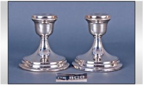 A Pair Of Silver Squat Candlesticks, raised on a circular stepped base. Hallmark Birmingham 1944.