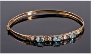 9ct Gold Hinged Bangle, The Front Set With Three Oval Blue Topaz Between Diamond Chip Spacers,