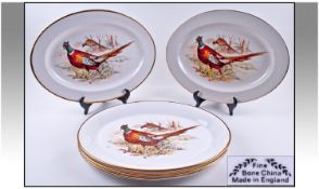 Six Large Oval Shaped Serving Plates, with pheasants scenes to central panels and gilt trim. 16 x