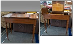 An Edwardian Stationary Writing Table In Walnut, with flap sides which open to reveal segmented