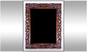 Wood Framed Large Mirror, frame in openwork scroll carved wood. bevelled glass. 27 by 34 inches.