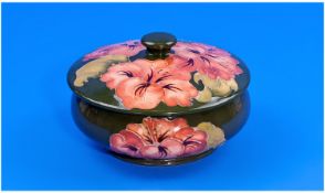 Moorcroft Round Lidded Powder Bowl `Coral Hibiscus` Design, on green colour way. Label to base.